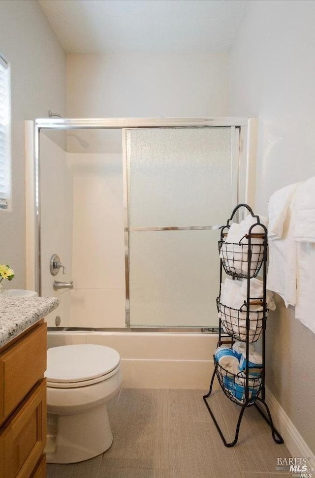 full bathroom with shower / bath combination with glass door, vanity, and toilet