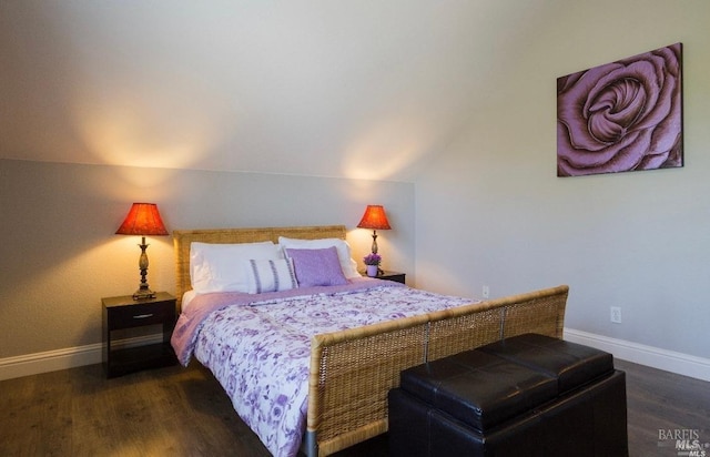 bedroom with vaulted ceiling and dark hardwood / wood-style flooring