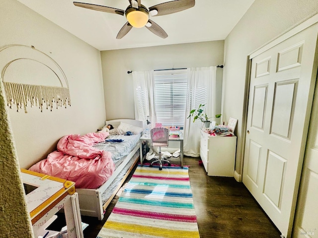 bedroom with dark hardwood / wood-style flooring and ceiling fan