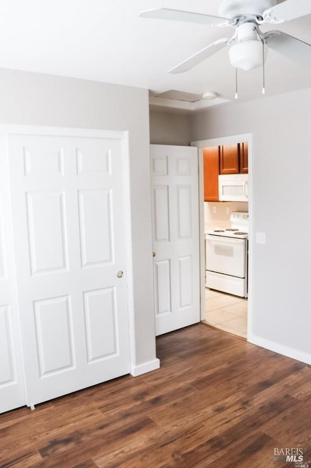 unfurnished bedroom featuring ceiling fan, a closet, and hardwood / wood-style floors