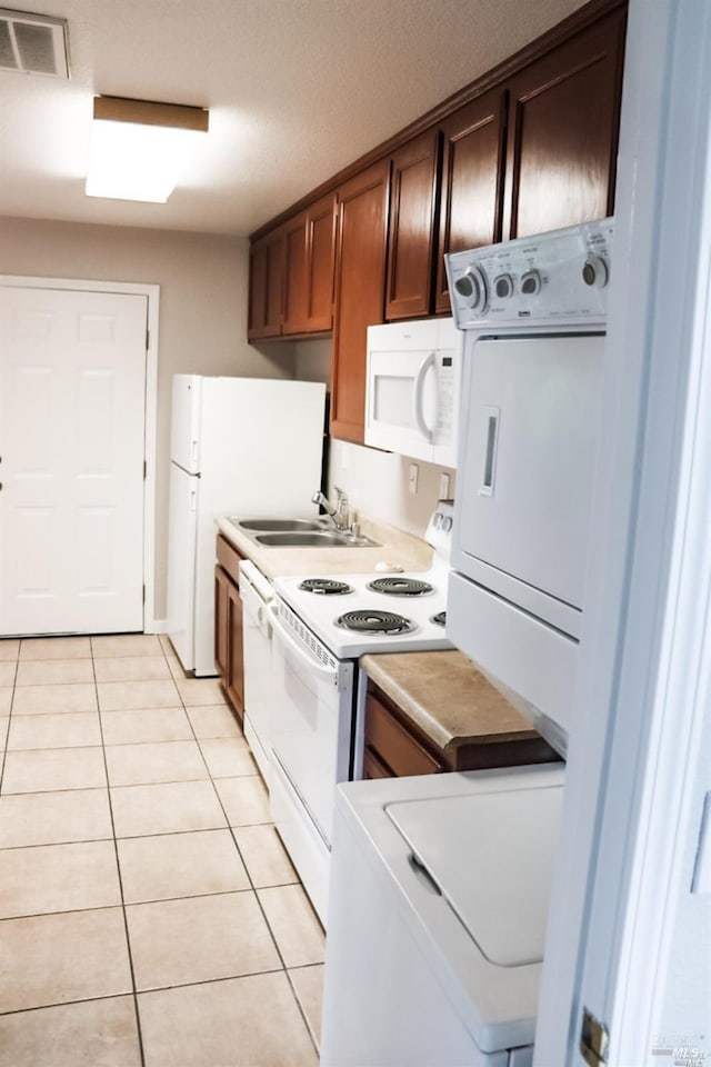 kitchen featuring light tile patterned floors, a textured ceiling, sink, and white appliances