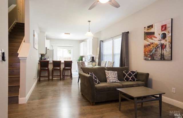 living room featuring ceiling fan and dark hardwood / wood-style flooring