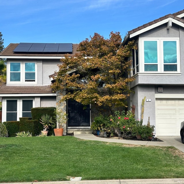 view of front of home featuring a front yard, a garage, and solar panels