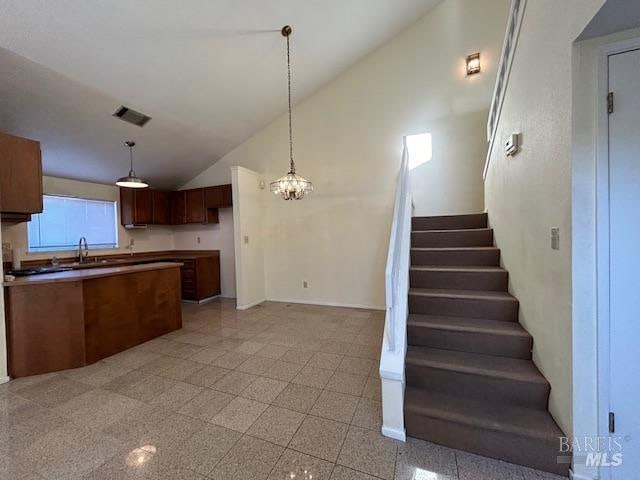 kitchen featuring high vaulted ceiling, a chandelier, and hanging light fixtures