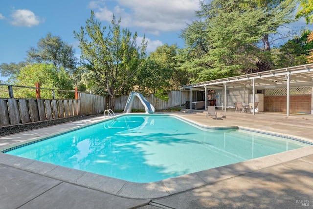 view of pool featuring a water slide and a patio area