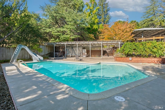 view of swimming pool featuring a water slide and a patio