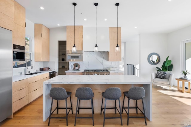 kitchen featuring decorative light fixtures, light hardwood / wood-style floors, and light brown cabinets