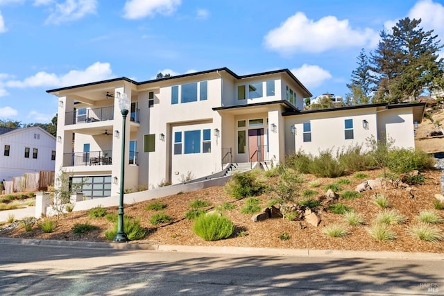 view of front of property with ceiling fan and a balcony