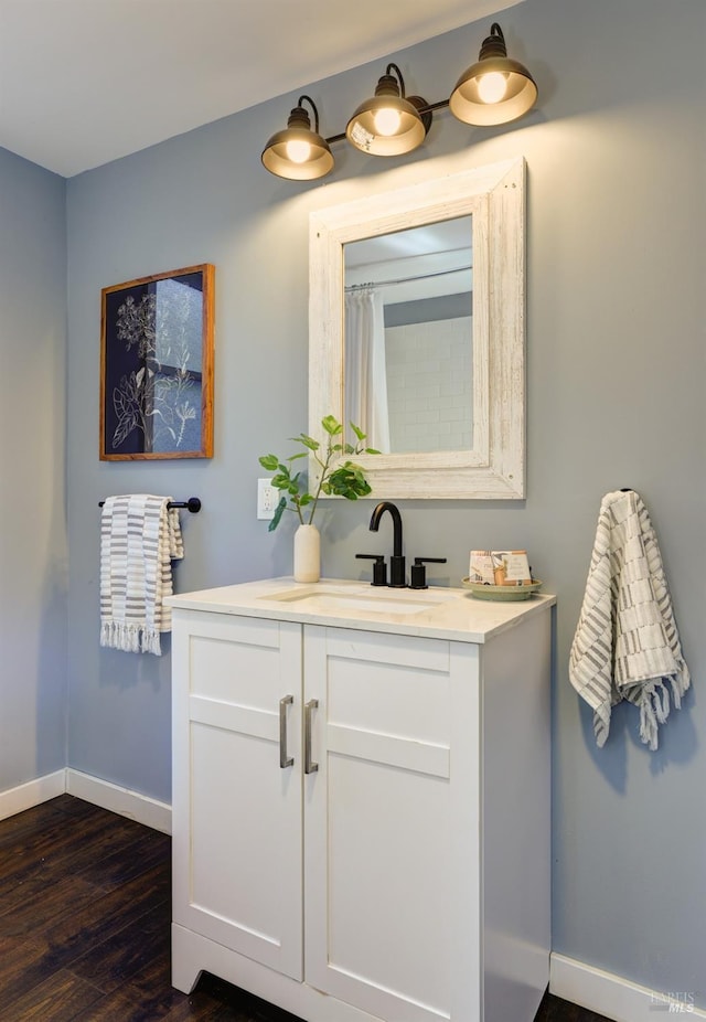 bathroom with vanity, baseboards, and wood finished floors