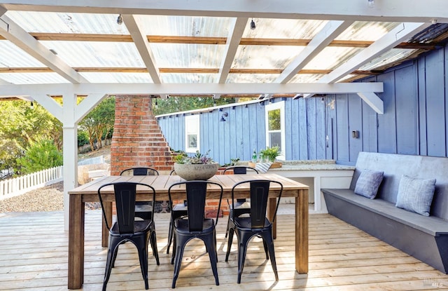 deck featuring an outdoor living space with a fireplace, exterior bar, and fence