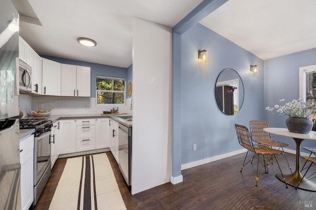 kitchen with decorative backsplash, dark wood-type flooring, stainless steel appliances, light countertops, and white cabinetry