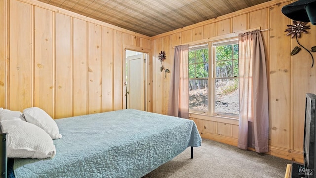 bedroom featuring carpet floors, wood walls, and crown molding