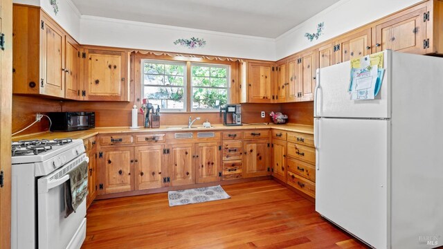 kitchen featuring light hardwood / wood-style flooring, crown molding, sink, and white appliances