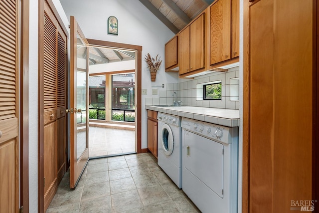 laundry room with light tile patterned floors, wooden ceiling, cabinets, sink, and washing machine and clothes dryer