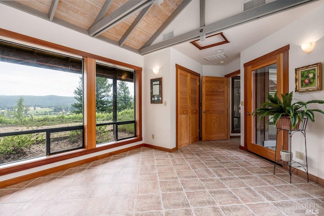 tiled spare room featuring vaulted ceiling with beams and a mountain view