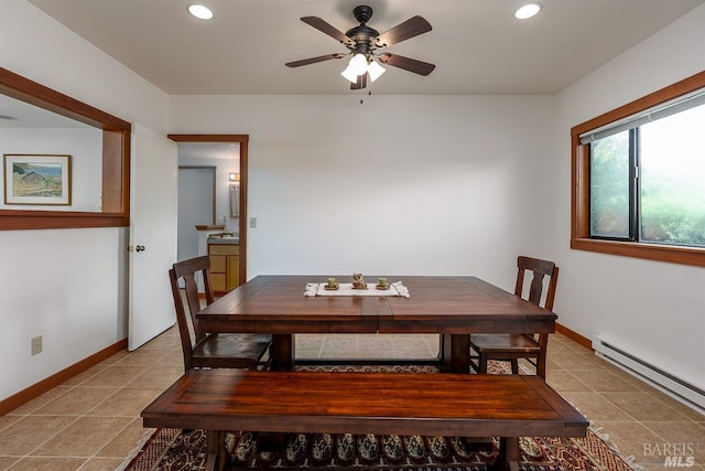 tiled dining space with ceiling fan and baseboard heating