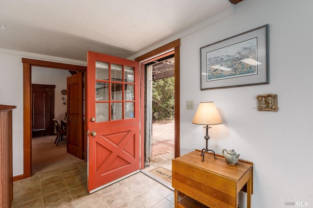 entrance foyer with a textured ceiling and tile patterned floors