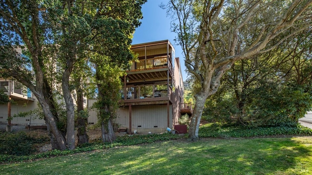 rear view of house with a balcony and a lawn