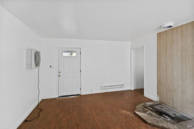 foyer entrance featuring a baseboard radiator, wood-type flooring, and a wall mounted AC