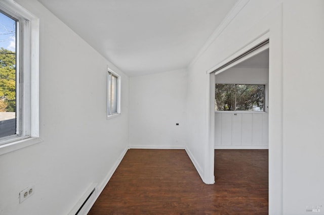 unfurnished room featuring ornamental molding, a wealth of natural light, and dark hardwood / wood-style flooring