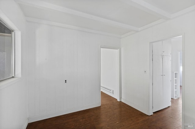 empty room with wood walls, a baseboard radiator, beam ceiling, and dark wood-type flooring