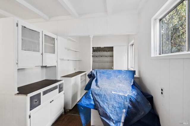 interior space with wooden walls and beamed ceiling