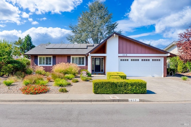 view of front of property with solar panels and a garage