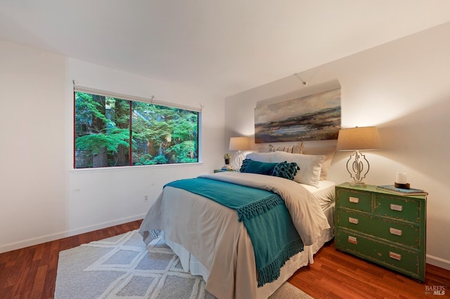 bedroom with dark hardwood / wood-style flooring