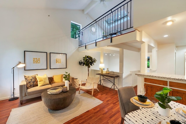 living room with beamed ceiling, dark hardwood / wood-style flooring, ceiling fan, and high vaulted ceiling