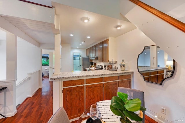 kitchen featuring stainless steel appliances, dark wood-type flooring, and kitchen peninsula