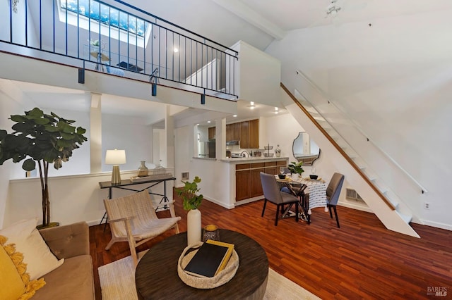 living room featuring beamed ceiling, hardwood / wood-style floors, and high vaulted ceiling