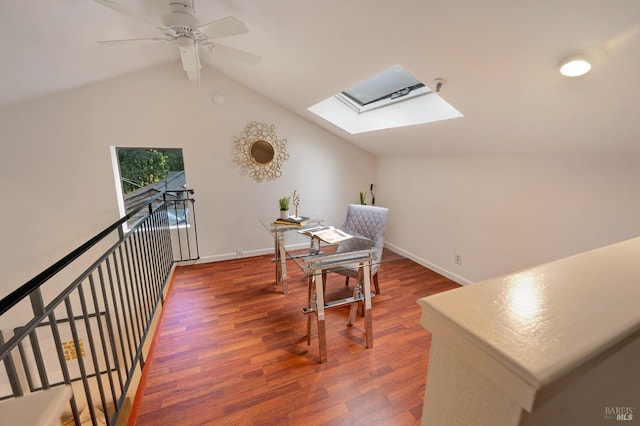 office area with vaulted ceiling with skylight, dark hardwood / wood-style floors, and ceiling fan