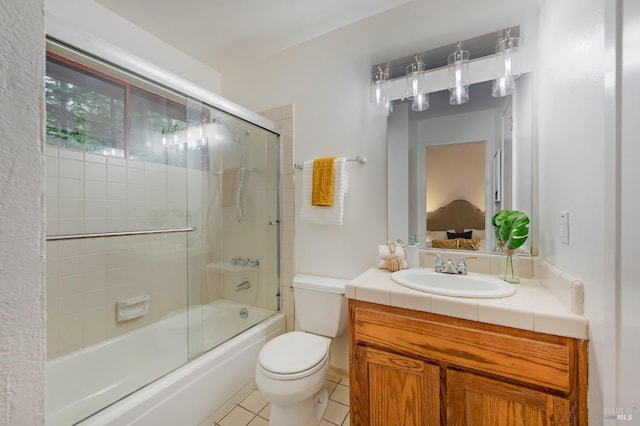 full bathroom featuring vanity, tile patterned flooring, toilet, and combined bath / shower with glass door