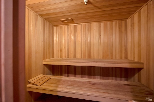 view of sauna with wood ceiling and wooden walls