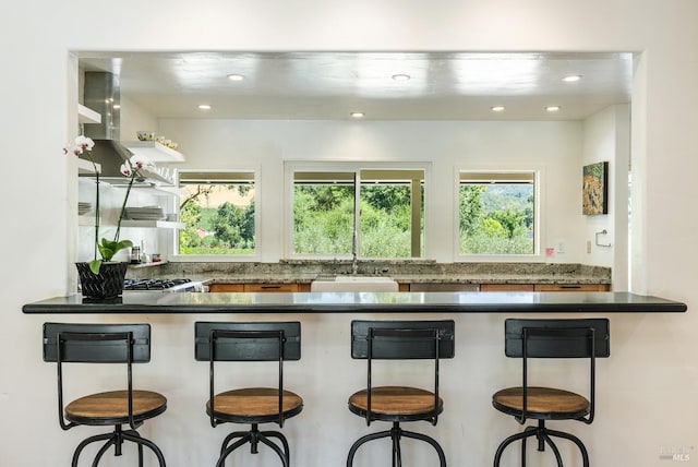 kitchen featuring a sink, dark countertops, plenty of natural light, and recessed lighting