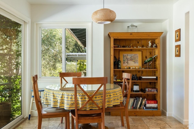 dining area featuring baseboards and stone tile floors