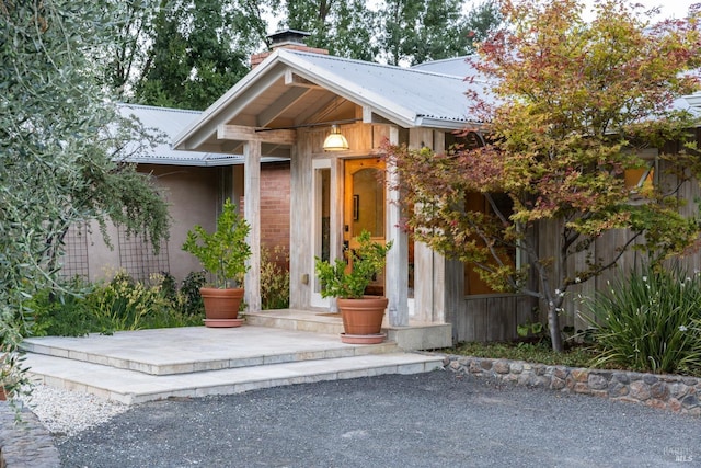 entrance to property with metal roof and a chimney