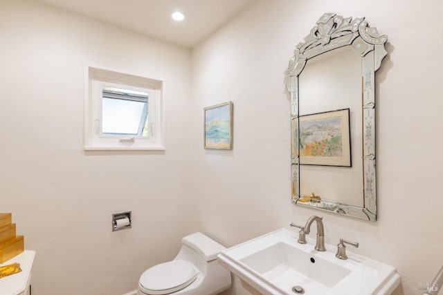 bathroom featuring toilet, a sink, and recessed lighting
