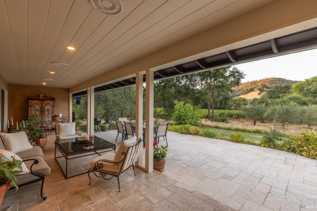 sunroom featuring wooden ceiling and a mountain view