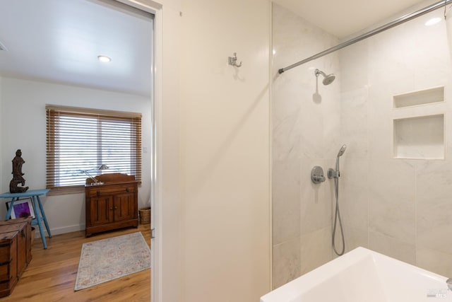 full bath featuring tiled shower and wood finished floors