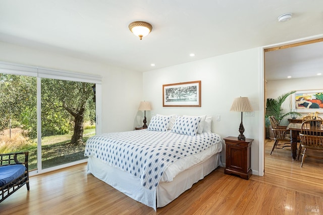 bedroom with access to exterior, recessed lighting, and wood finished floors
