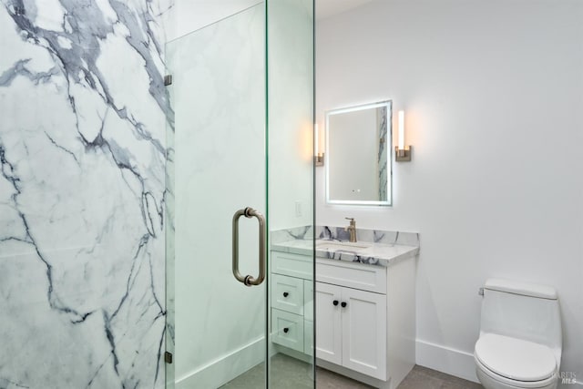 bathroom featuring a shower with door, vanity, toilet, and tile patterned flooring