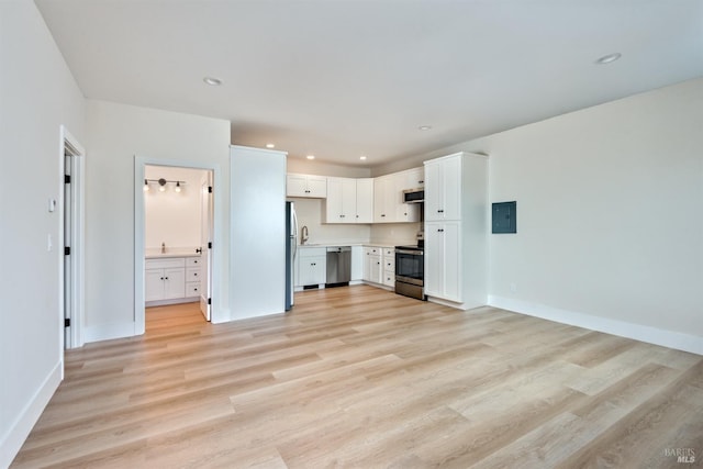 unfurnished living room featuring electric panel and light wood-type flooring