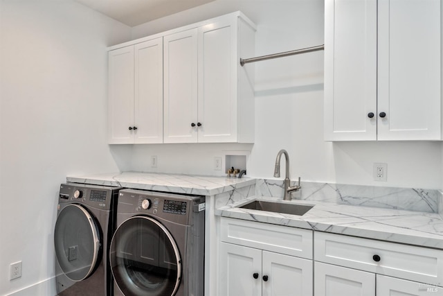 clothes washing area featuring cabinets, sink, and washing machine and dryer