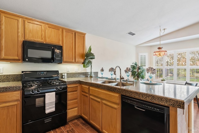 kitchen featuring visible vents, a peninsula, wood finish floors, black appliances, and a sink