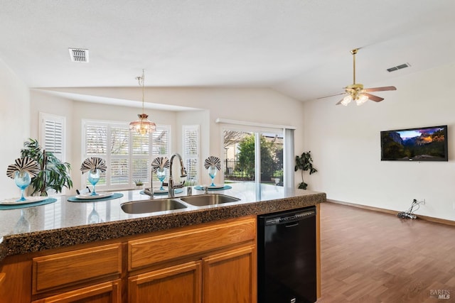 kitchen featuring black dishwasher, vaulted ceiling, a sink, and visible vents