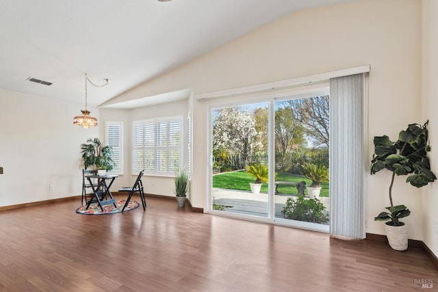 interior space featuring vaulted ceiling, wood finished floors, visible vents, and baseboards