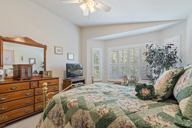 carpeted bedroom with ceiling fan and vaulted ceiling