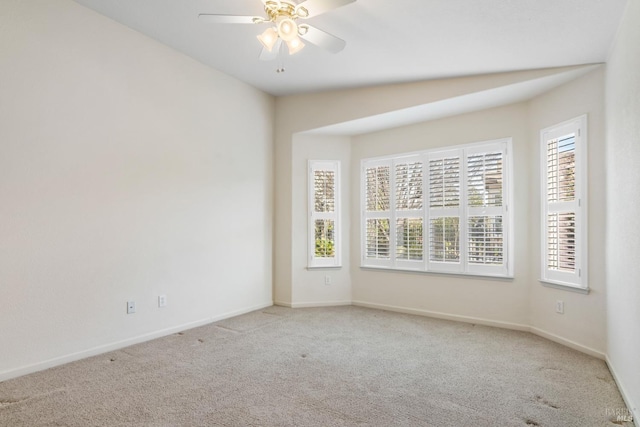 carpeted empty room featuring a ceiling fan and baseboards