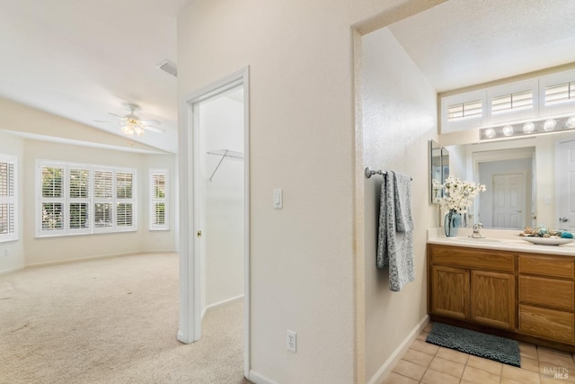 bathroom featuring lofted ceiling, a ceiling fan, vanity, baseboards, and tile patterned floors